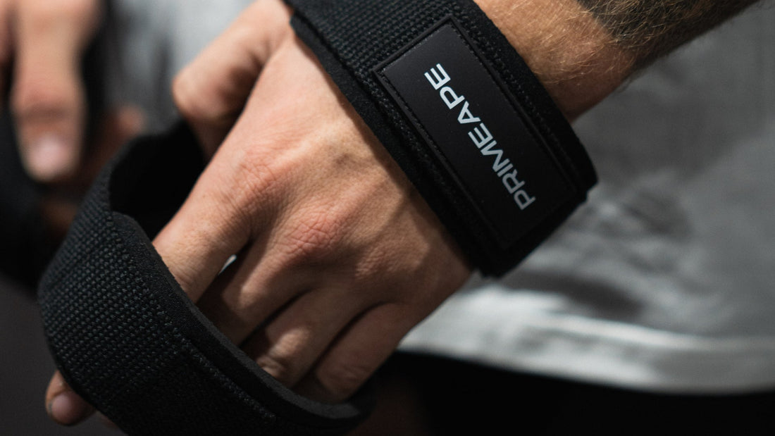 Close-up of hands wrapping a Prime Ape branded lifting strap, a high-quality piece of fitness gear for weightlifting and strength training
