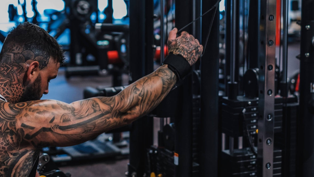 Tattooed man wearing a lifting grip